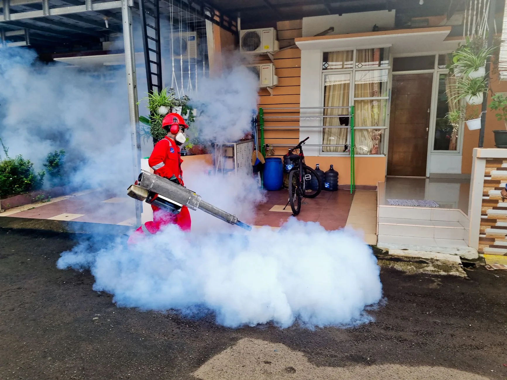 Pest control technician treating Kent WA rental property interior under landlord agreement